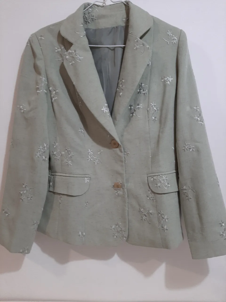 Blazer entallado con bordado floral sutil en toda la prenda. Posee un solo botón al frente y bolsillos con solapa. Ideal para un look elegante y femenino.