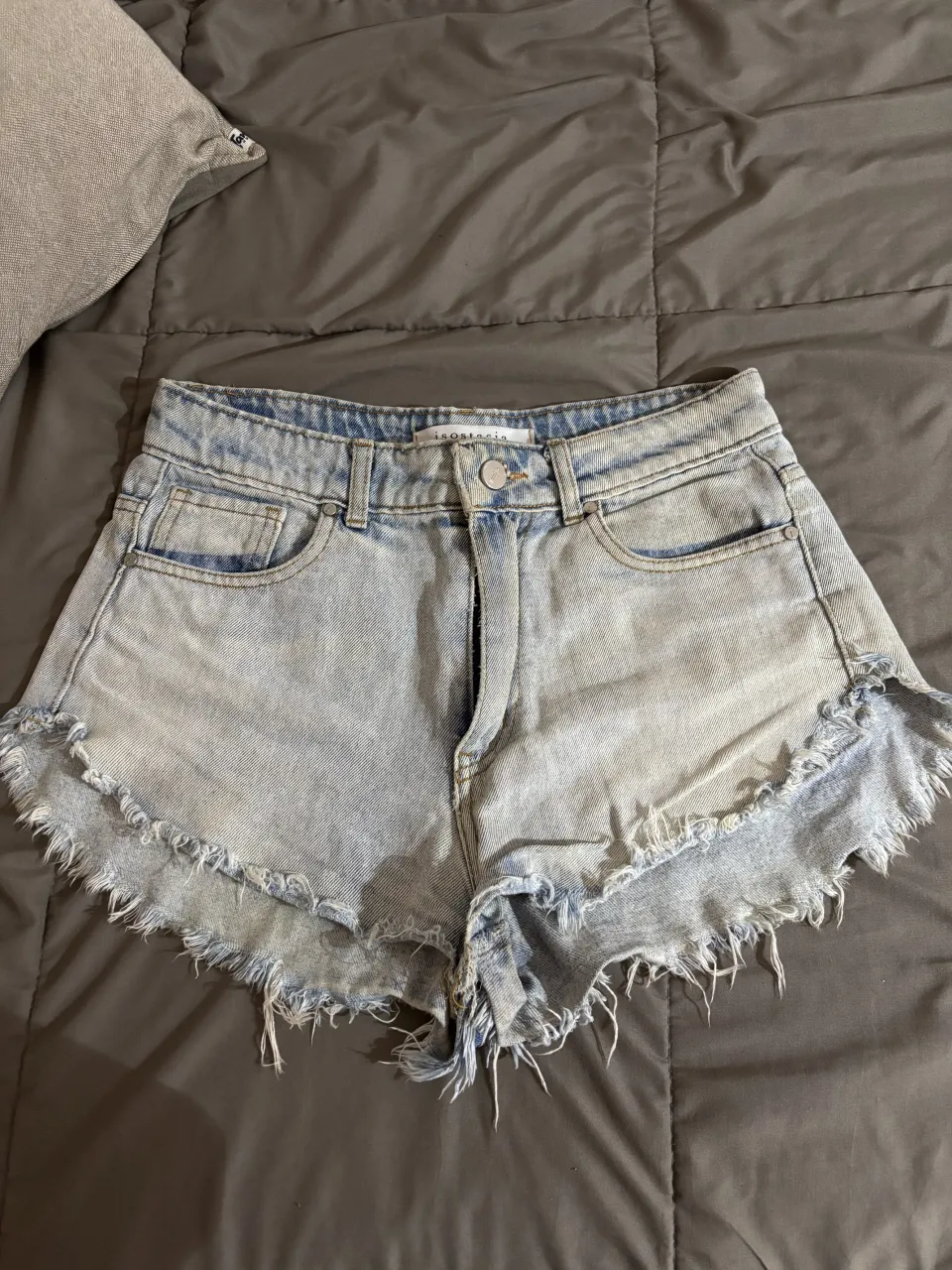 Shorts de jean tiro alto con detalles desflecados en los bordes. Lavado claro con efecto desgastado. Perfectos para un look casual de verano. talle 40arg