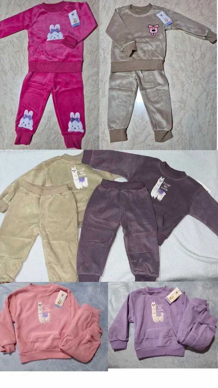 Conjunto de dos piezas de plush para niña, compuesto por un buzo de cuello redondo y pantalón largo. El buzo tiene un estampado de llama en el frente. El pantalón es liso.