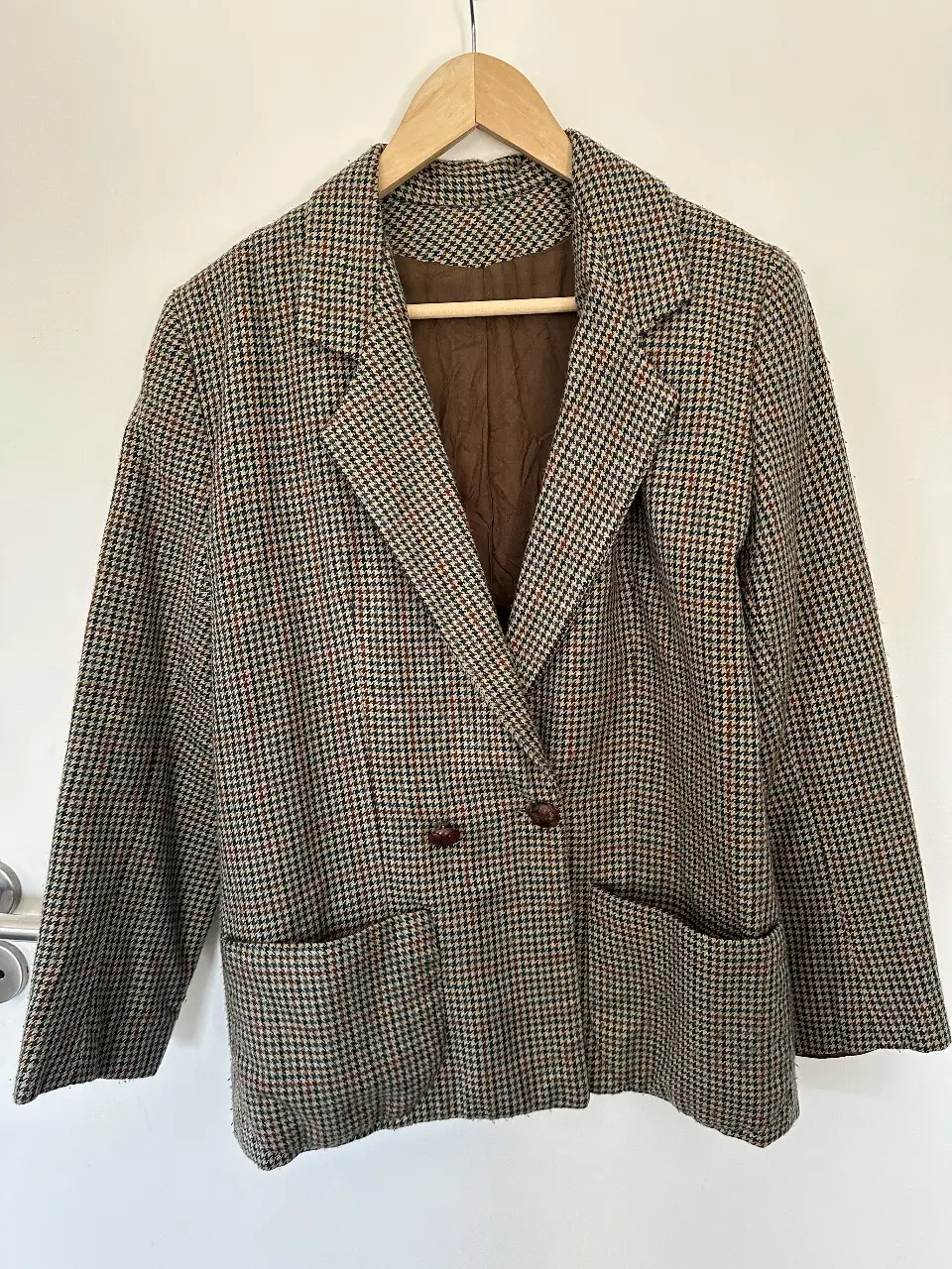 Blazer de hombre vintage con estampado de cuadros en tonos marrones y verdes. Corte clásico con dos botones y bolsillos delanteros. Ideal para un look elegante y retro.