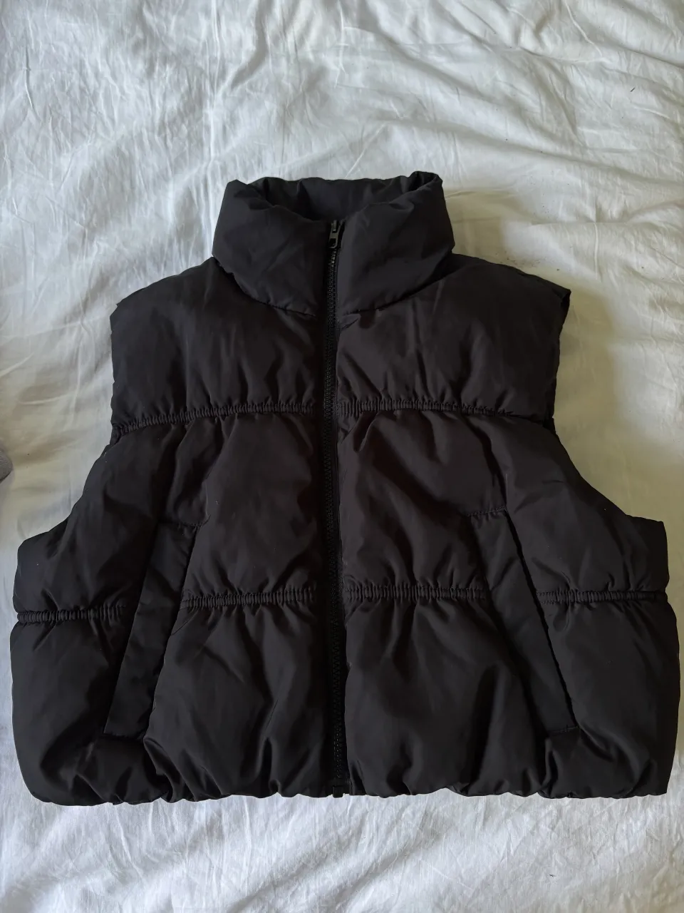 Chaleco acolchado negro con cuello alto y cierre al frente. Cortito puffer, como nuevo sin uso. 