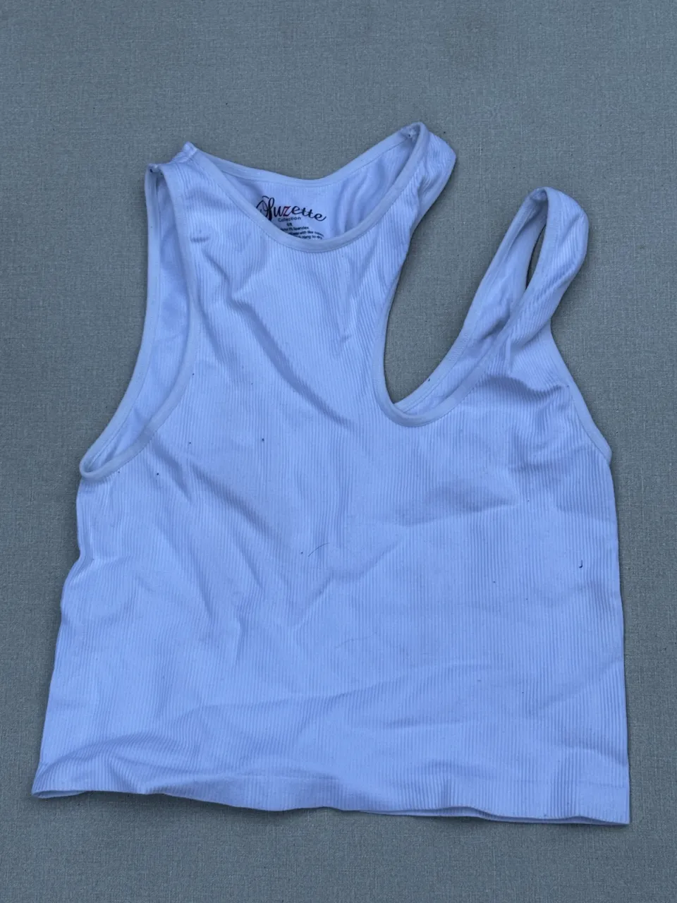 Musculosa blanca de morley, con diseño asimétrico y tiritas cruzadas en el hombro. Ideal para un look casual y moderno.

Detalles: manchas visibles en la foto