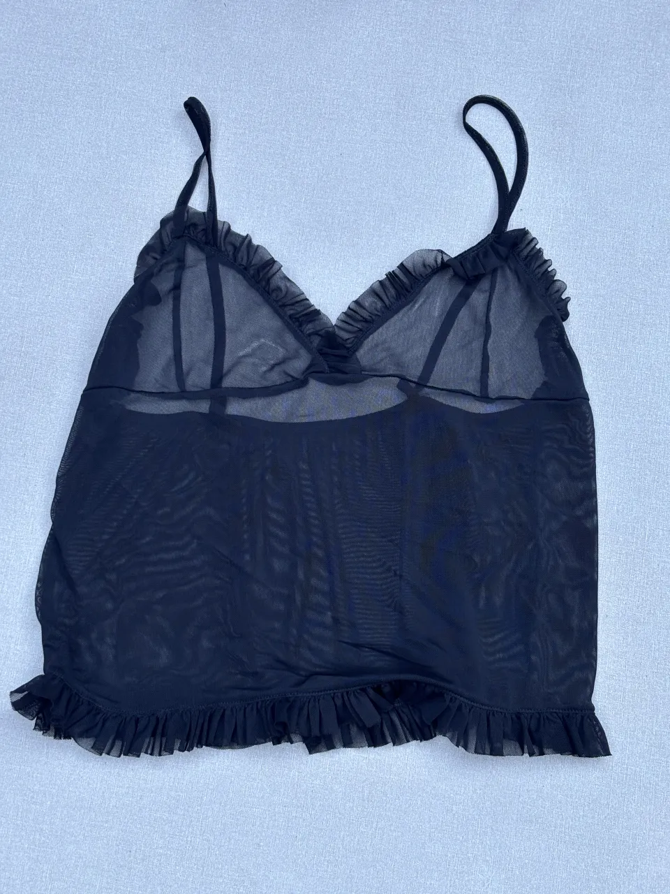 Conjunto de lencería negro de tul con volados. Incluye corpiño y bombacha. Ideal para ocasiones especiales o para sentirse sensual.