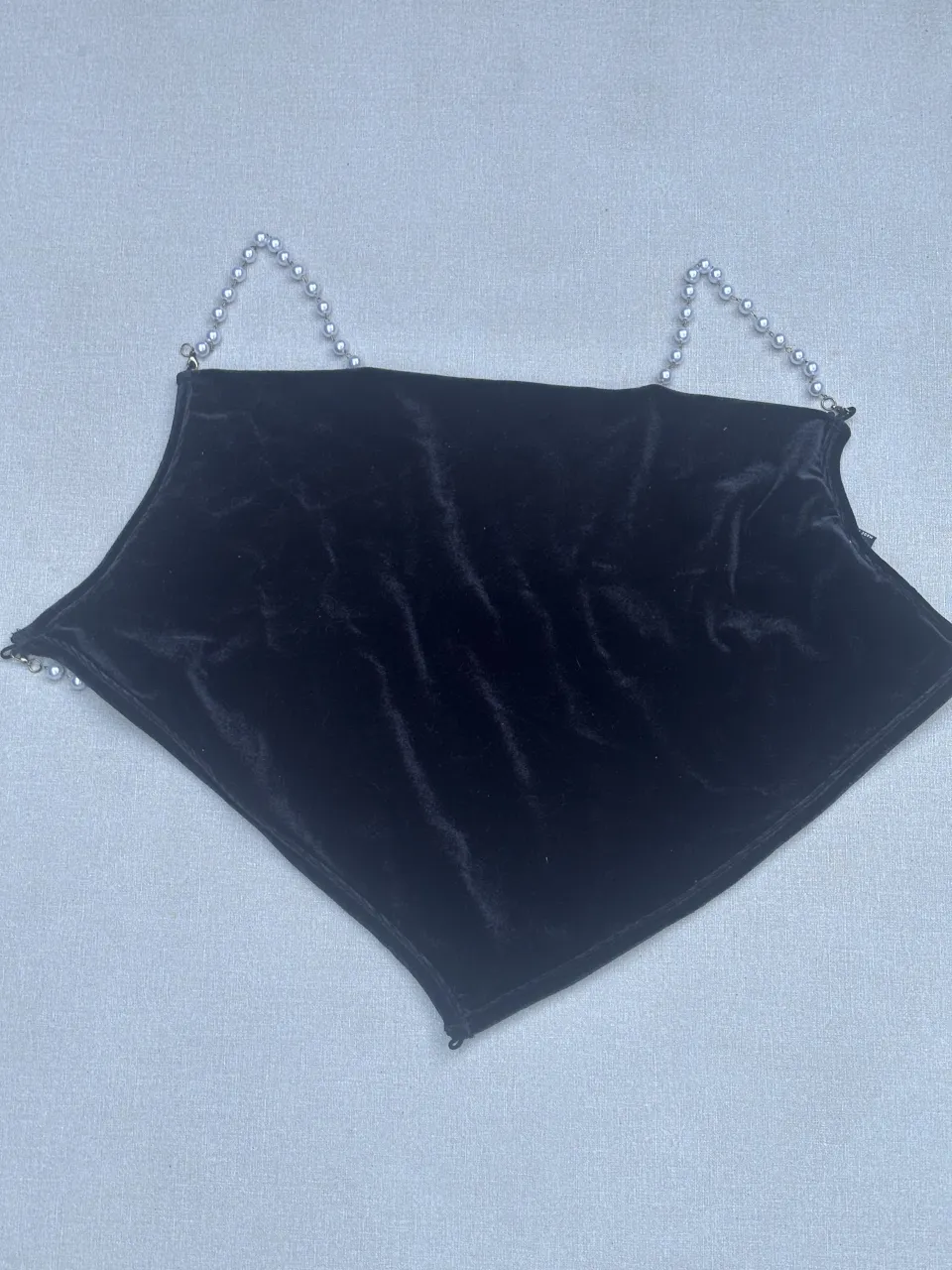 Top negro de terciopelo con detalles de perlas. Ideal para un look canchero y moderno.