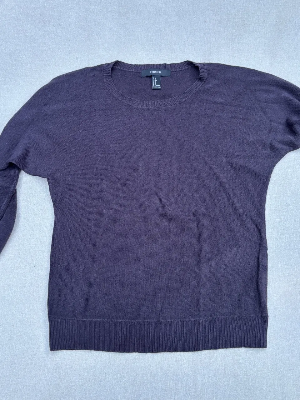 Sweater de hilo fino en color azul marino. Posee cuello redondo y mangas largas con puño. Ideal para un look casual y cómodo.