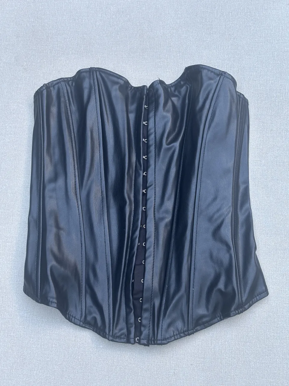 Corpiño de cuero negro, ideal para un look audaz y moderno. Perfecto para combinar con jeans o faldas para una salida nocturna o un evento especial. Su diseño estructurado realza la figura.