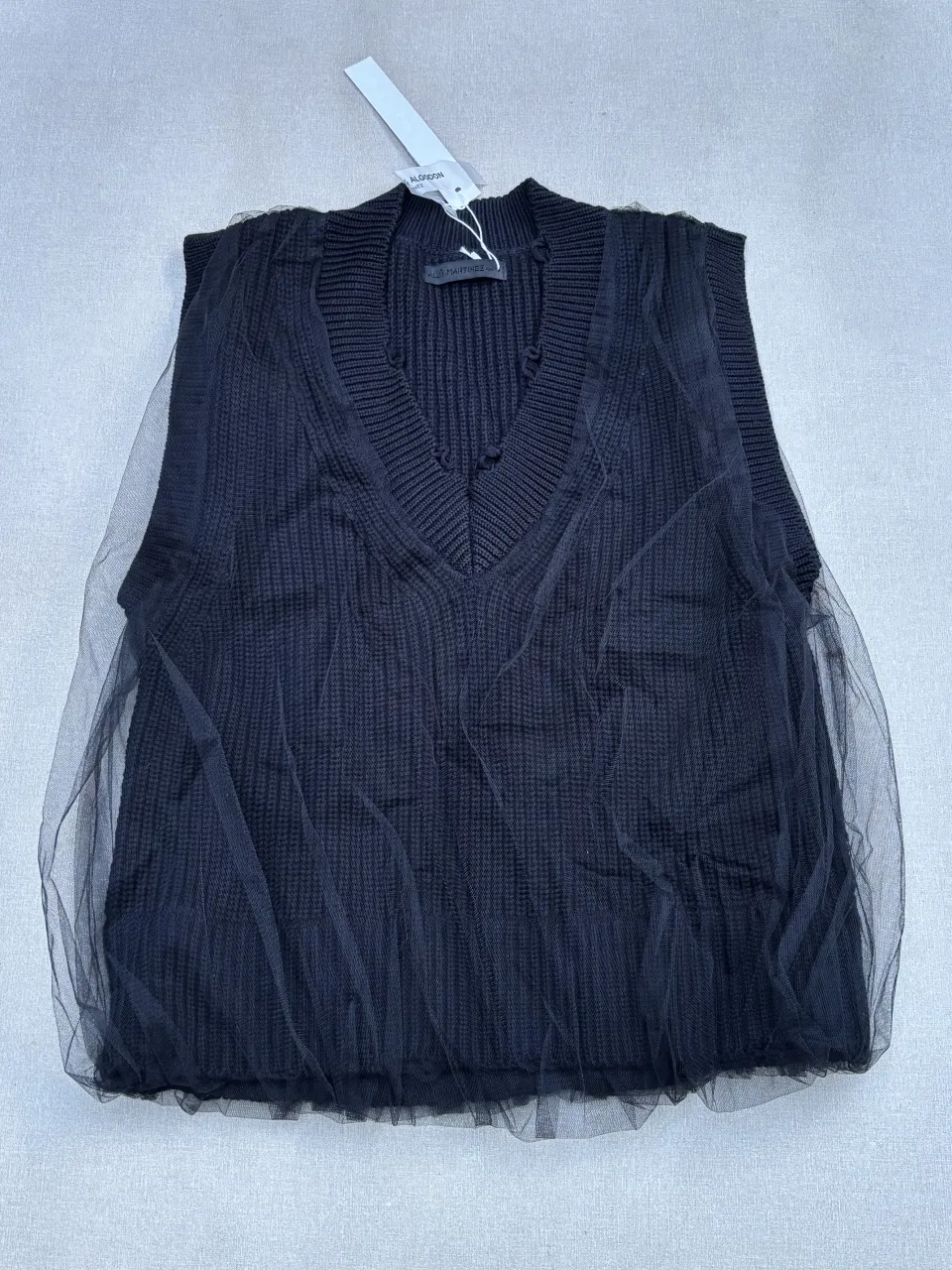 Chaleco de tejido de punto negro con detalles de tul. Un diseño moderno y elegante, perfecto para superponer y darle un toque chic a tus outfits.

La etiqueta talle 44