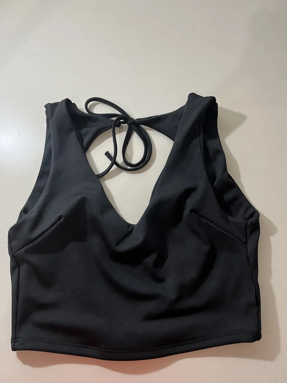 Top negro con escote en V y lazo en la espalda.