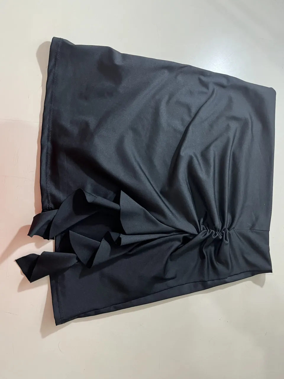 Pollera negra con detalle de fruncido y volados en un lateral.