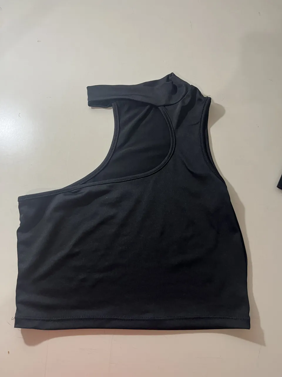 Musculosa negra con recorte en el hombro.