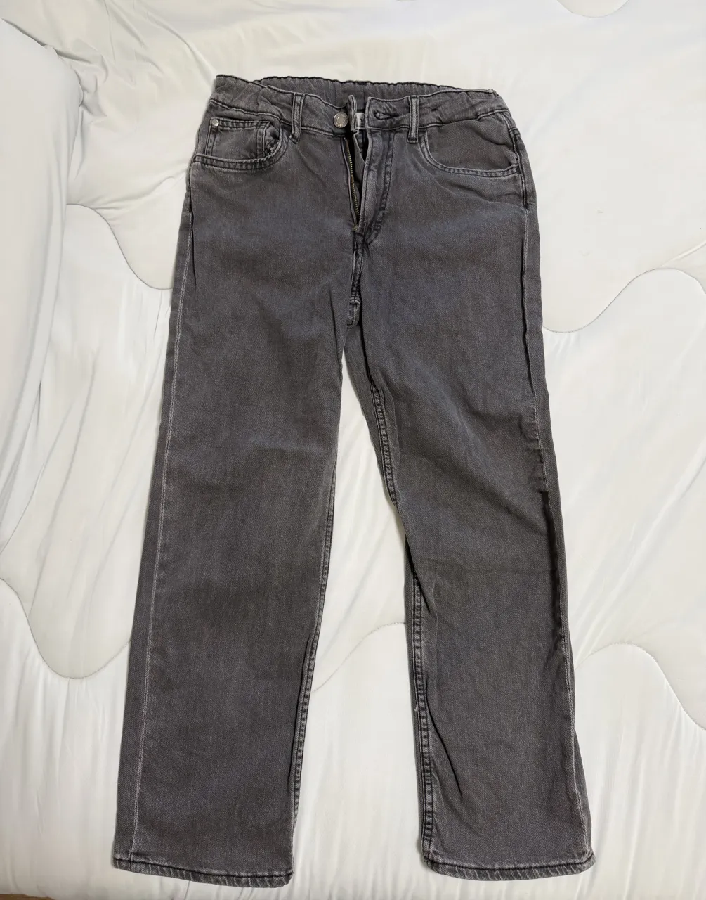 Jean de color gris oscuro. Cierre con botón y cierre.