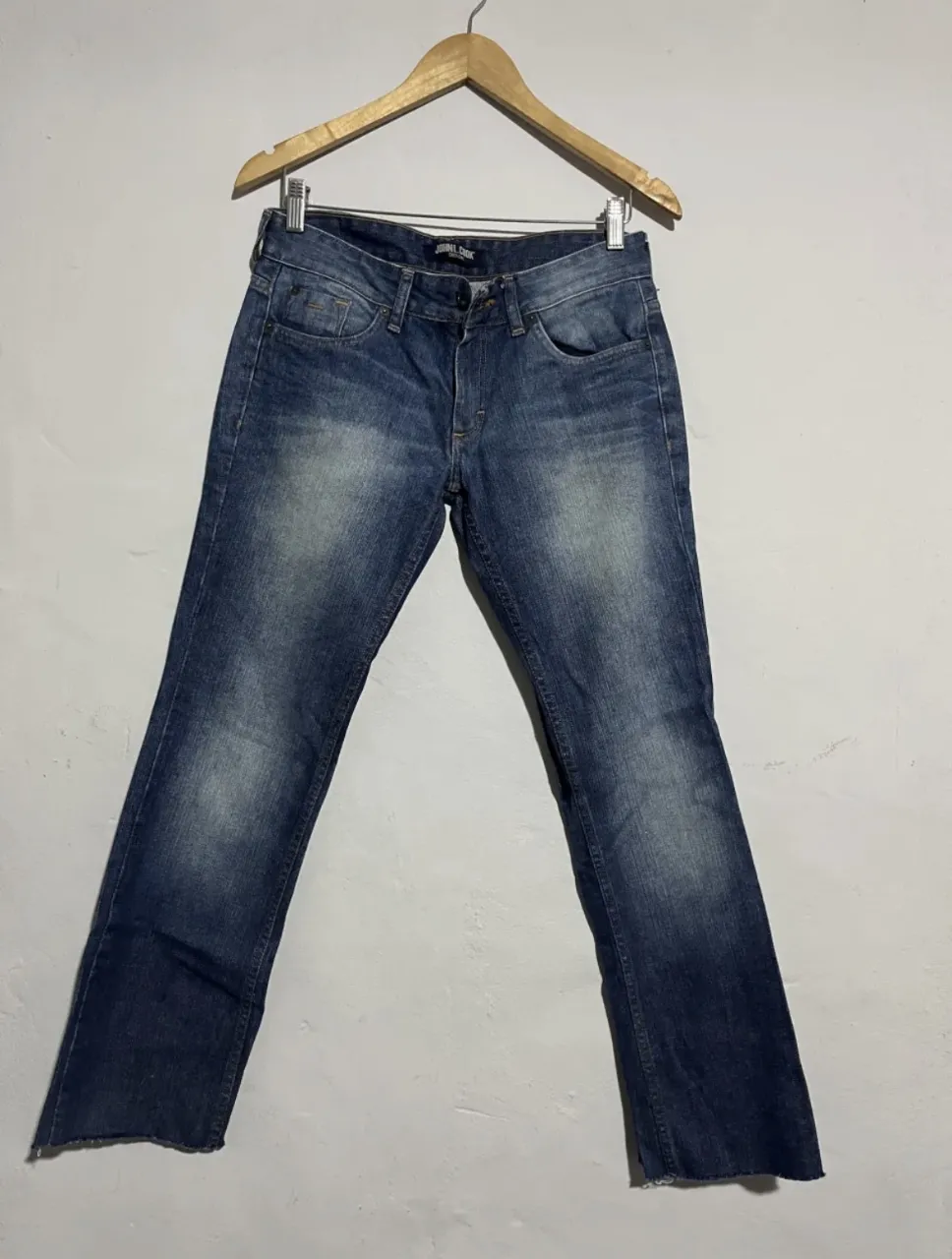 Jeans de corte clásico, color azul con desgastes. Cierre y botón.