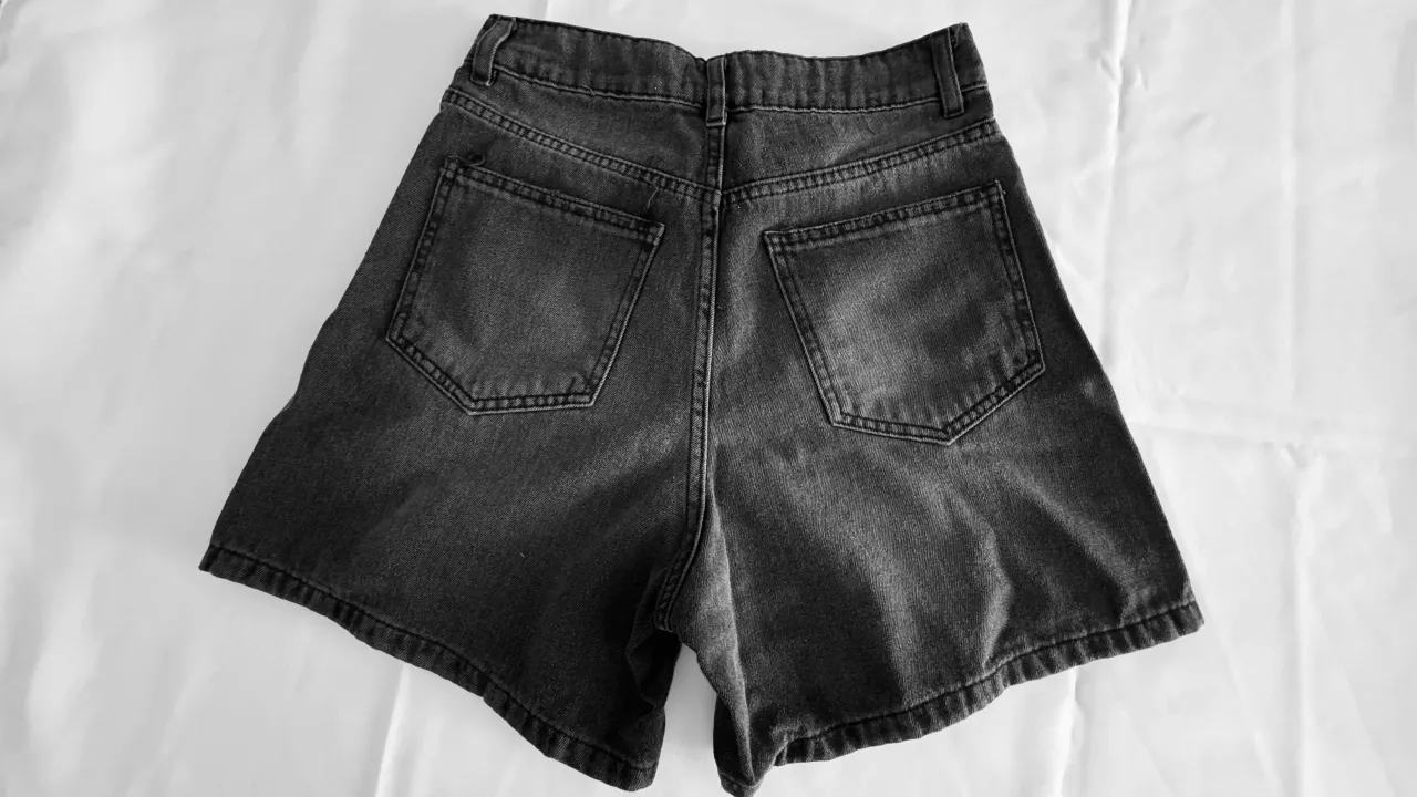 Shorts de jean grises con roturas.