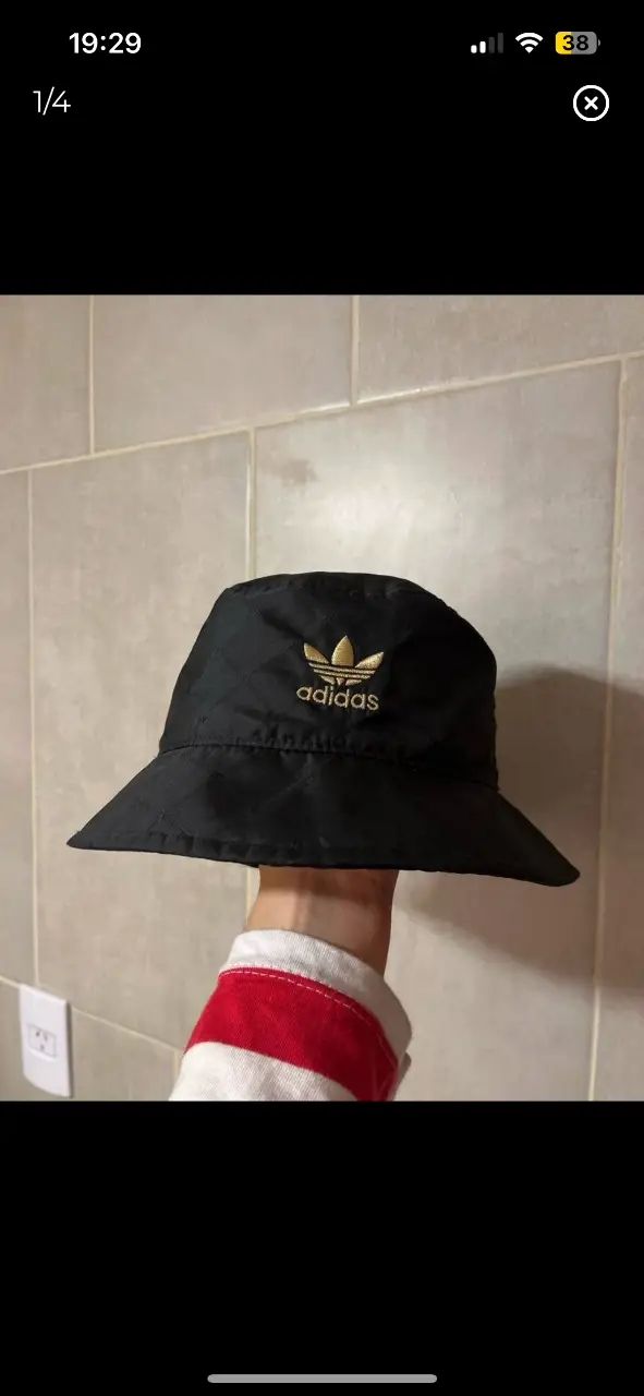 Piluso de color negro con el logo de Adidas en dorado. Ideal para un look casual y urbano. unisex