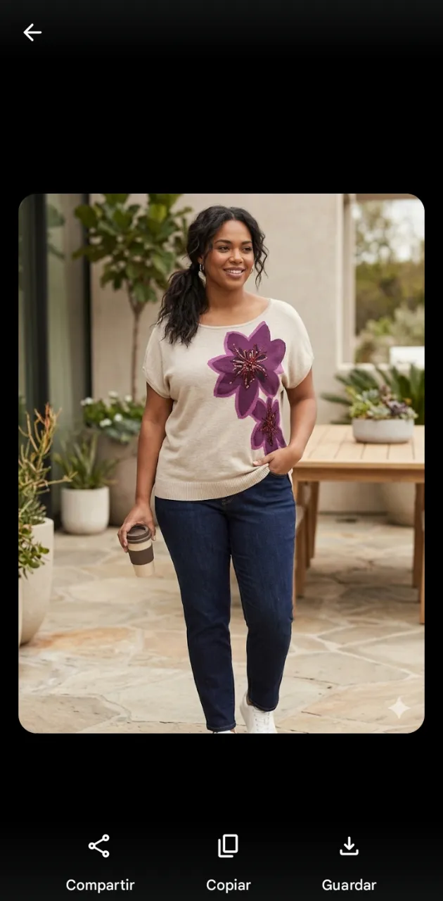 Remera de tejido liviano color beige con aplique de dos flores bordadas con lentejuelas en color fucsia y detalles en negro.