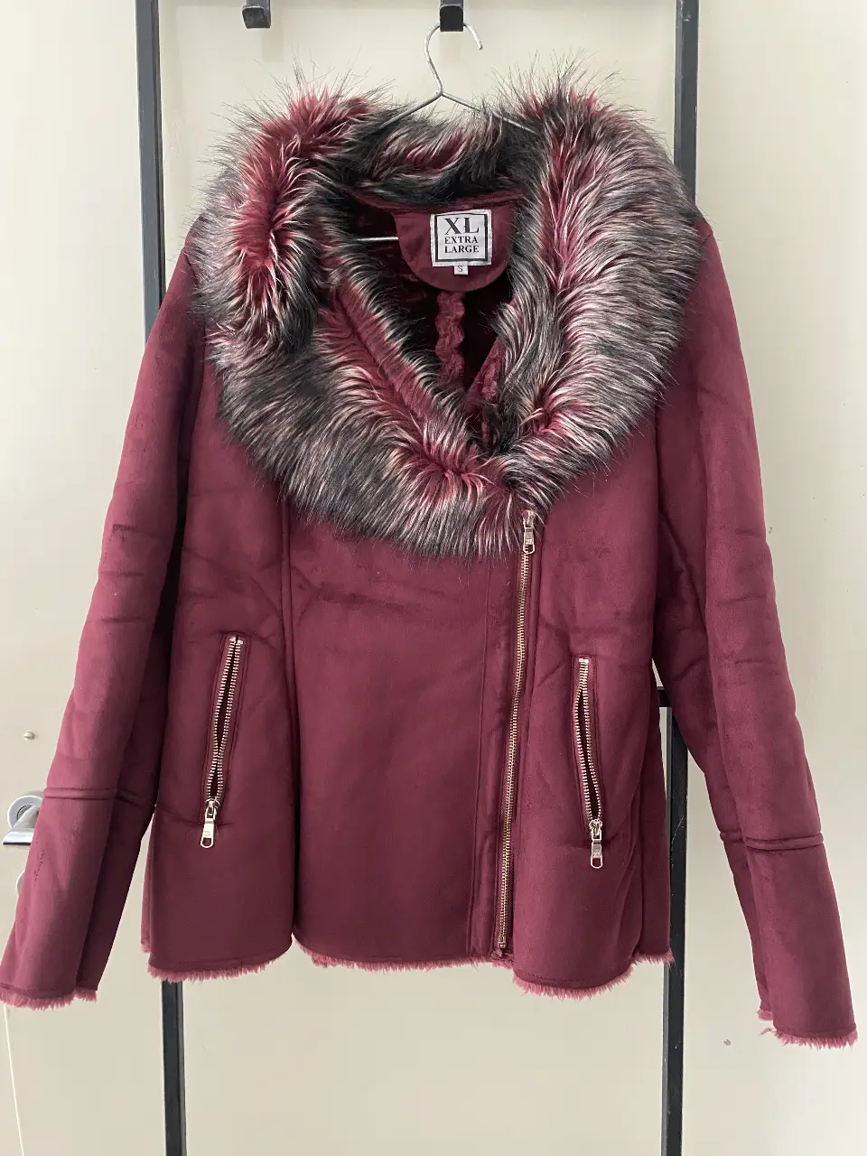 Campera de mujer estilo biker en color borgoña con cuello de piel sintética. Posee cierre y bolsillos con cremalleras. Ideal para el invierno.