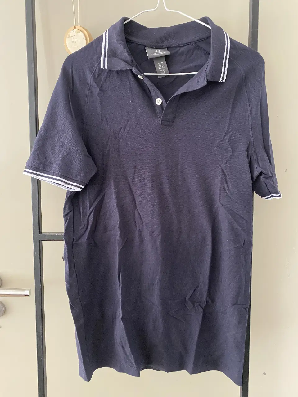 Remera polo de hombre, color azul marino con detalles blancos en el cuello y mangas. Corte relajado, ideal para un look casual y cómodo. Marca H&M, talle XS.