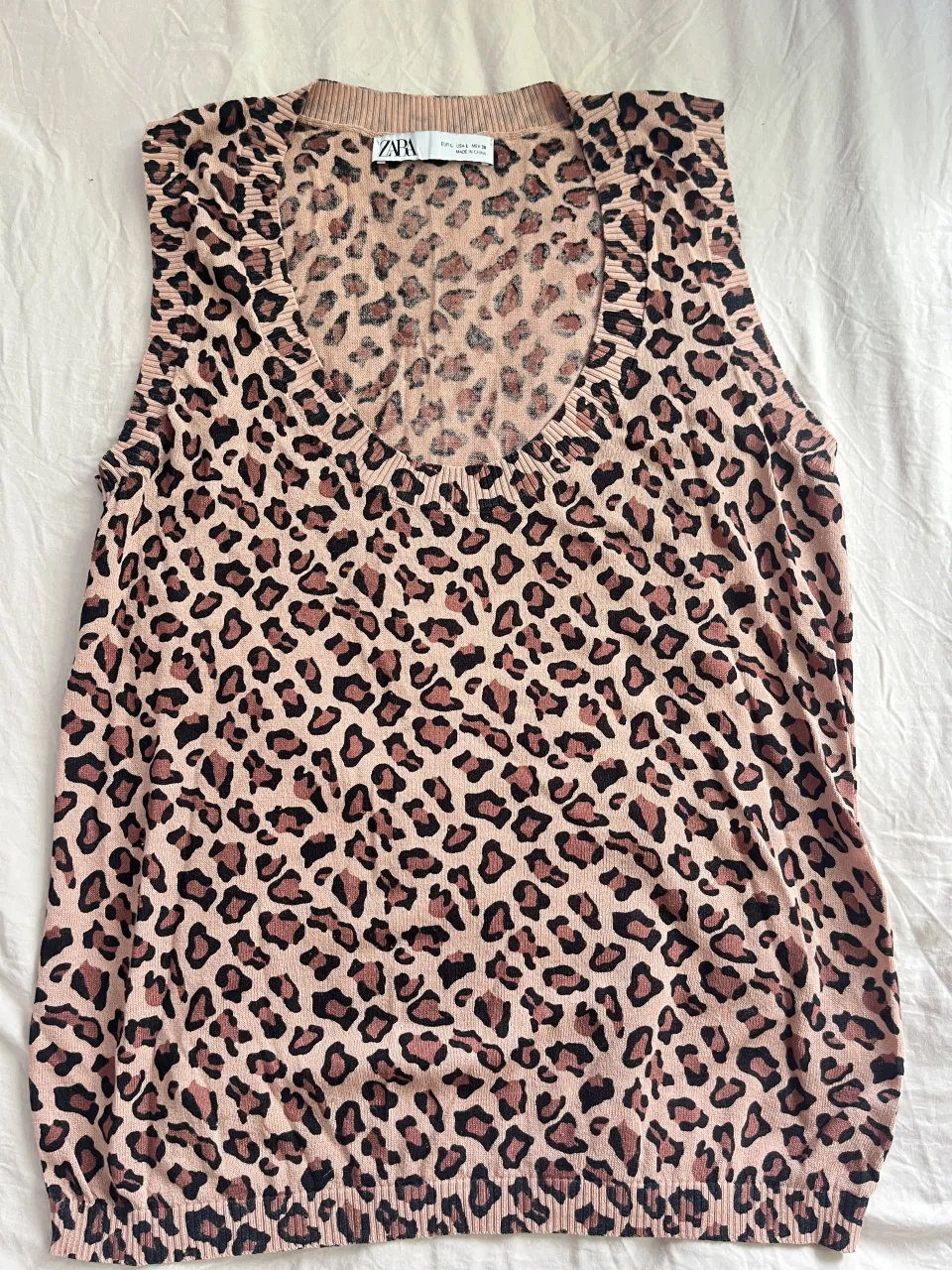 Musculosa de tejido con estampa de leopardo en tonos rosas y marrones. Cuello redondo.