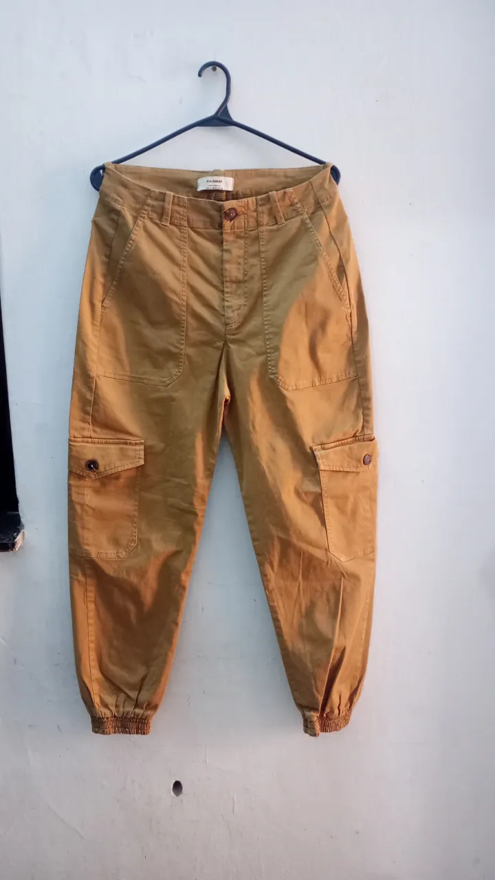 Pantalon marca Pull&Bear. talle 26/36. elastizado, tiro alto, puño en la botamanga. bolsillos tipo cargo. Medidas aprox. en plano: cintura 34 cm, tiro delantero 30 cm, tiro trasero 36 cm, largo 94 cm. laterales y traseros.