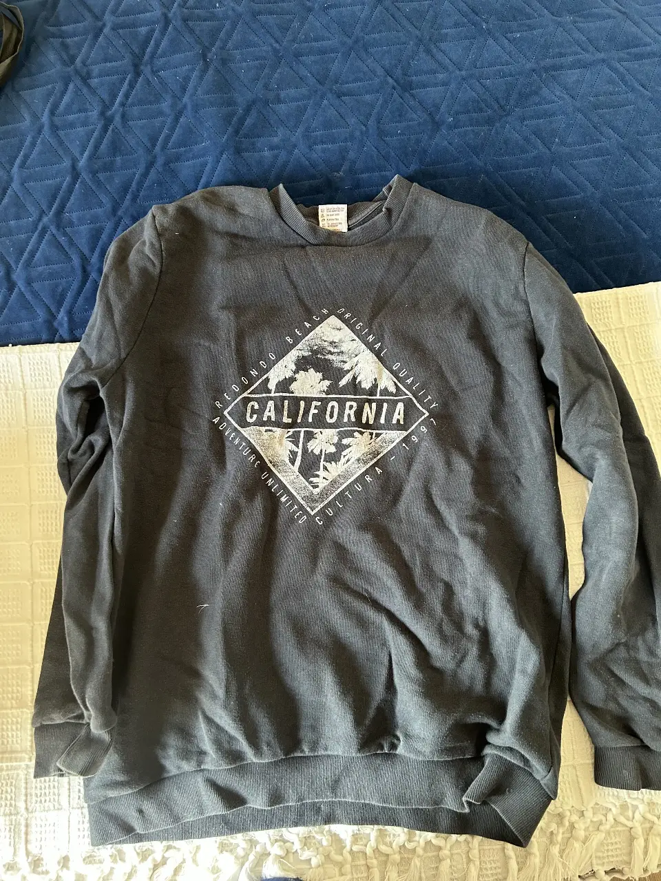 Buzo de cuello redondo negro con estampado "California" en la parte delantera. Ideal para un look casual y relajado.