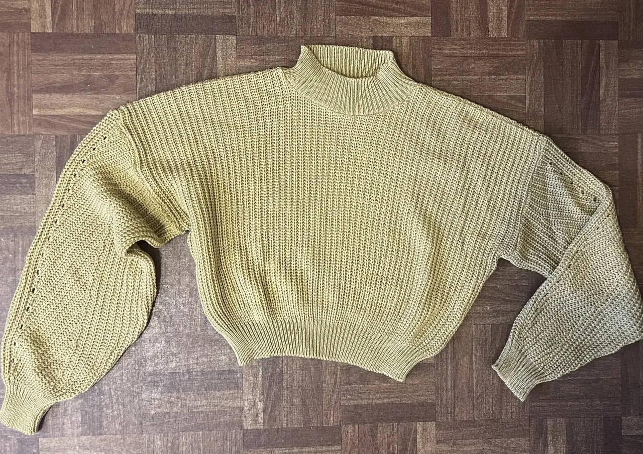 Sweater tejido de cuello alto, con mangas largas y detalles calados. Un básico canchero para el día a día.