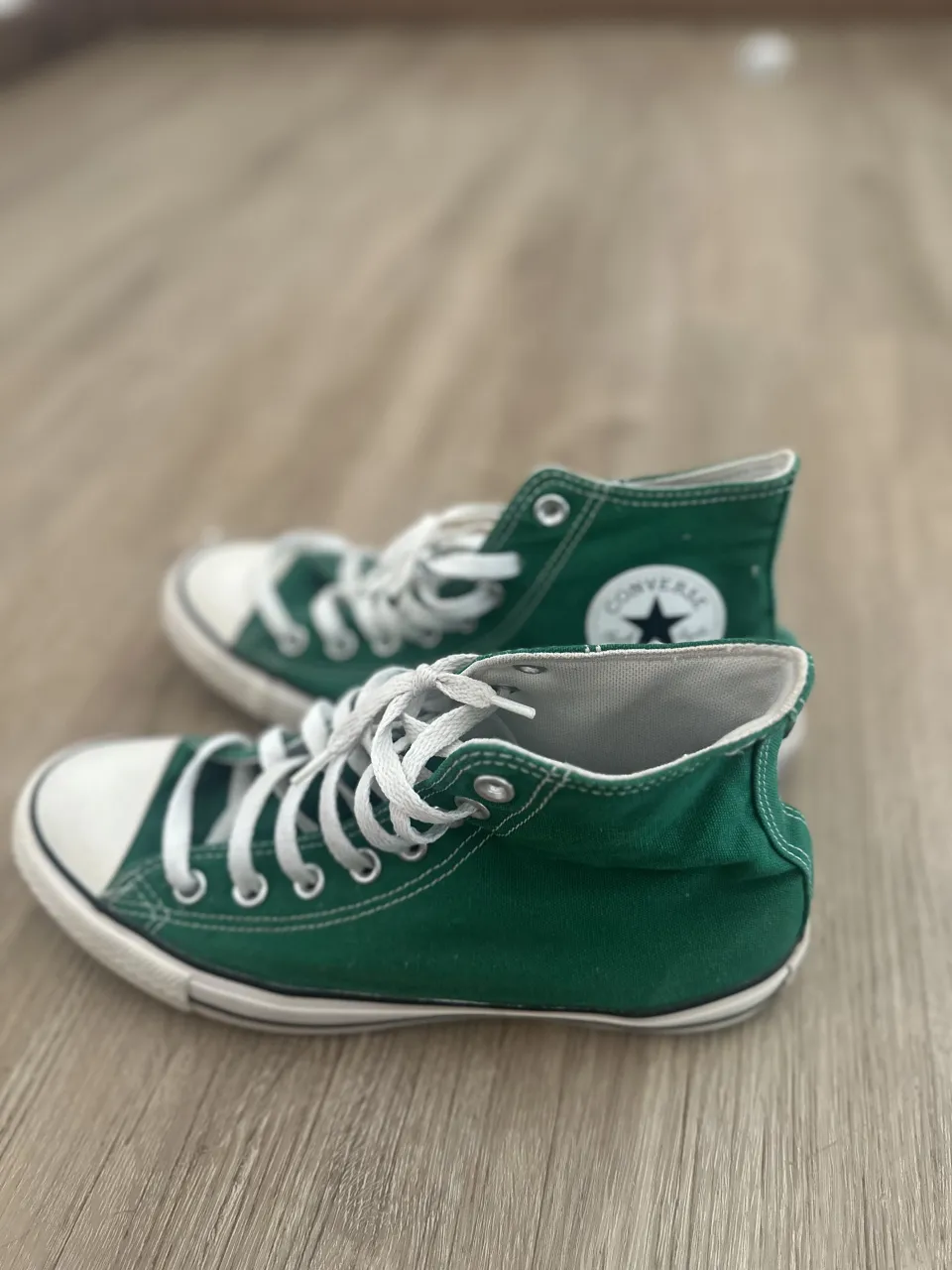 Zapatillas Converse altas de lona color verde con cordones blancos y puntera blanca.