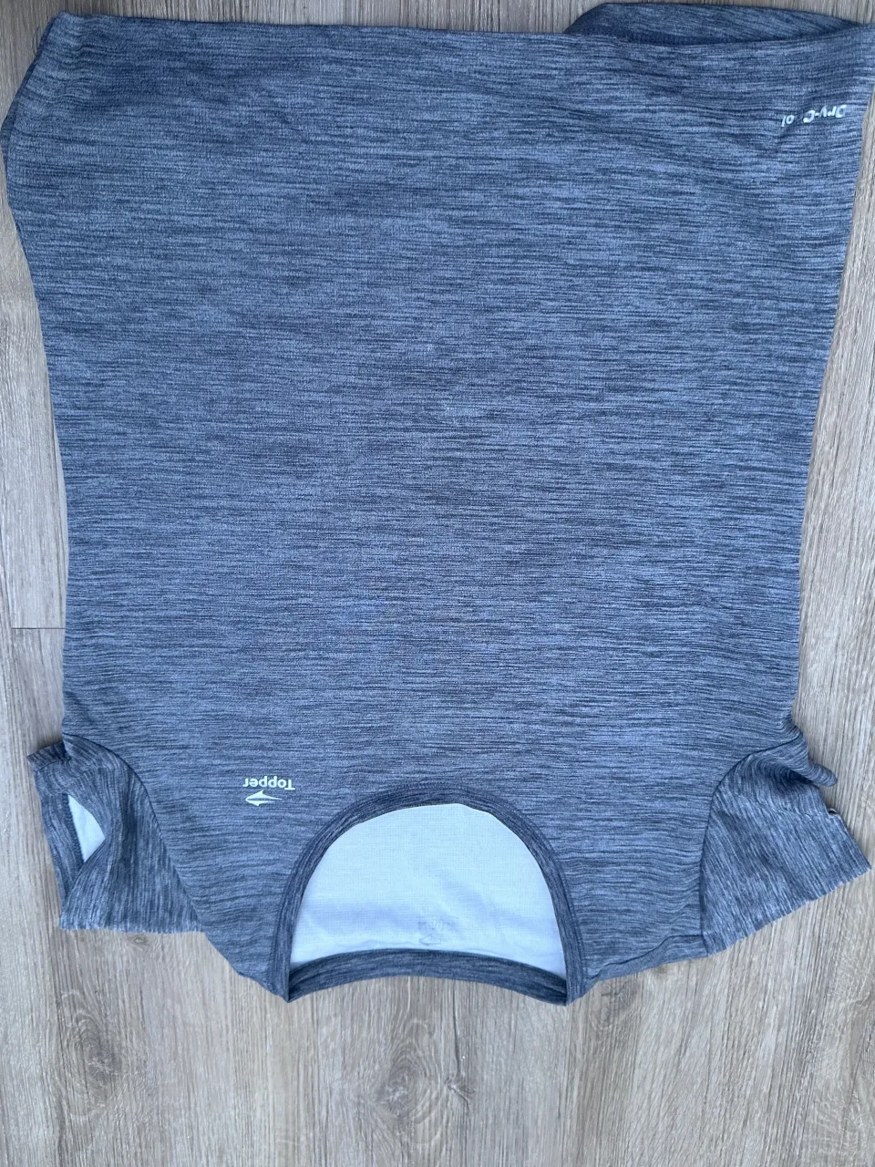 Remera deportiva gris melange con logo blanco de la marca en el pecho y detalle en la manga.