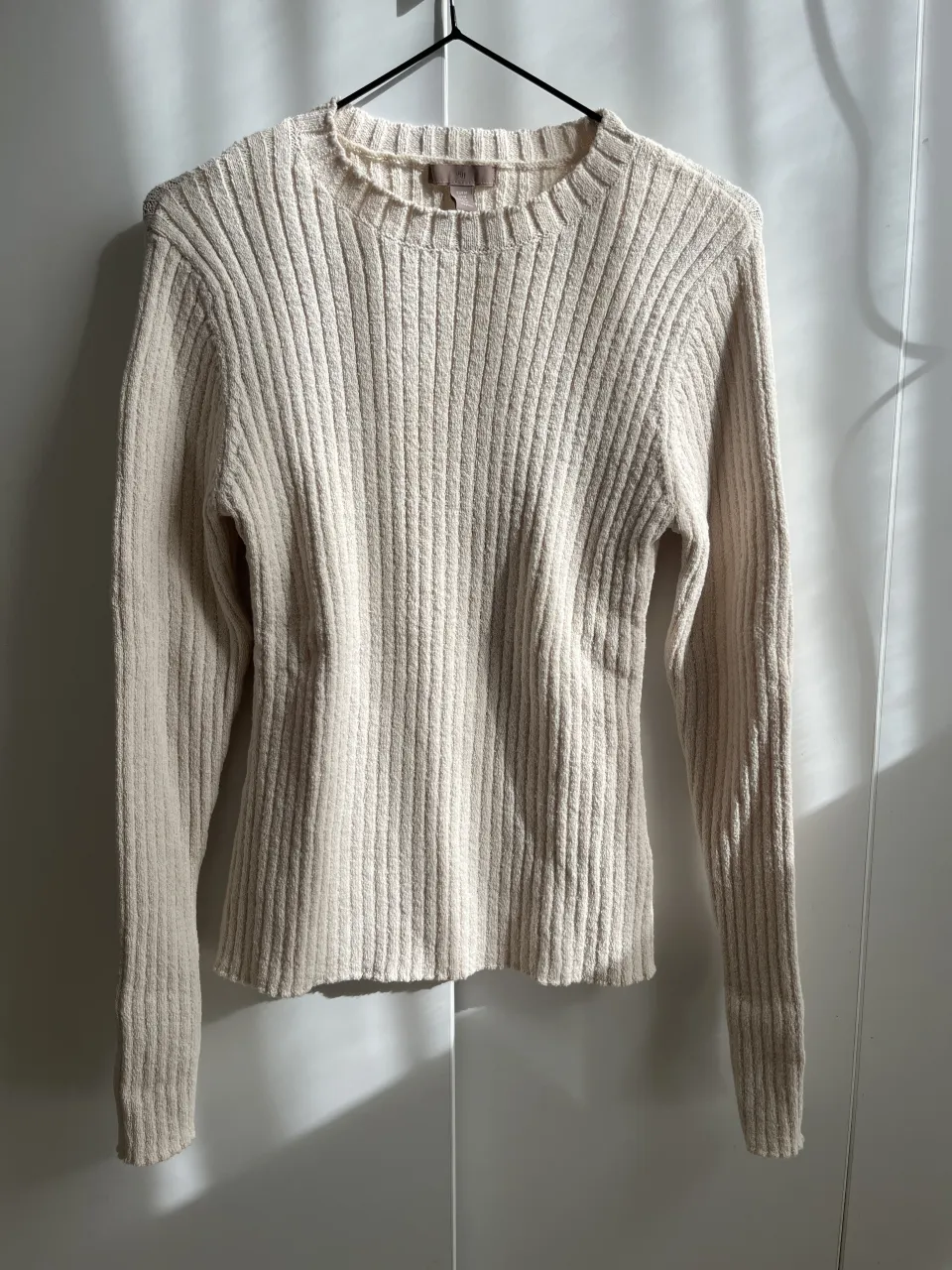 Sweater de tejido acanalado en color crudo. Manga larga y cuello redondo. Un básico ideal para el día a día.