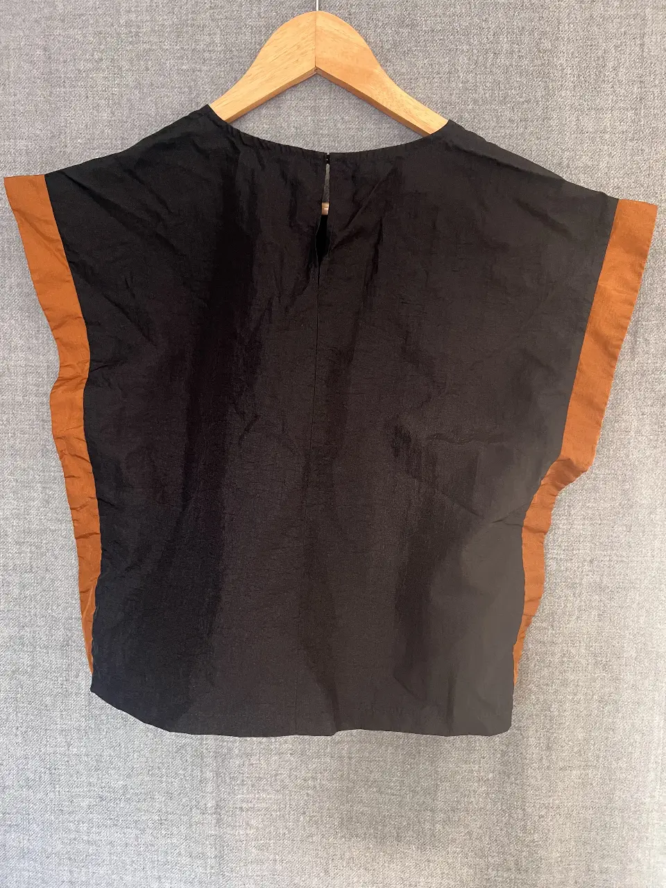 Top negro con detalles en marrón. Diseño moderno y elegante, ideal para combinar con diferentes outfits. Perfecto para un look casual o para salir.