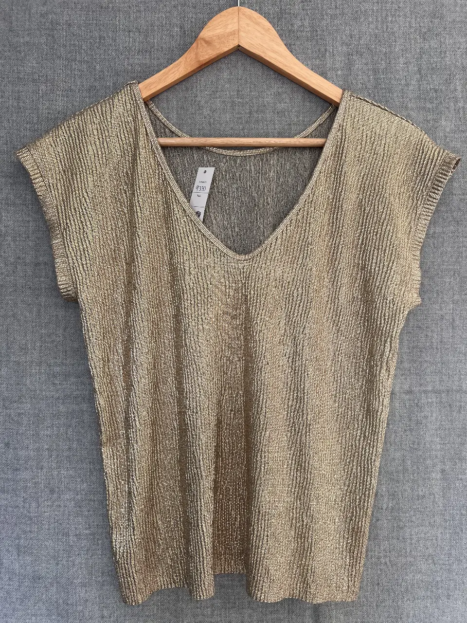 Remera dorada con cuello en V y mangas cortas. Ideal para un look elegante y sofisticado.