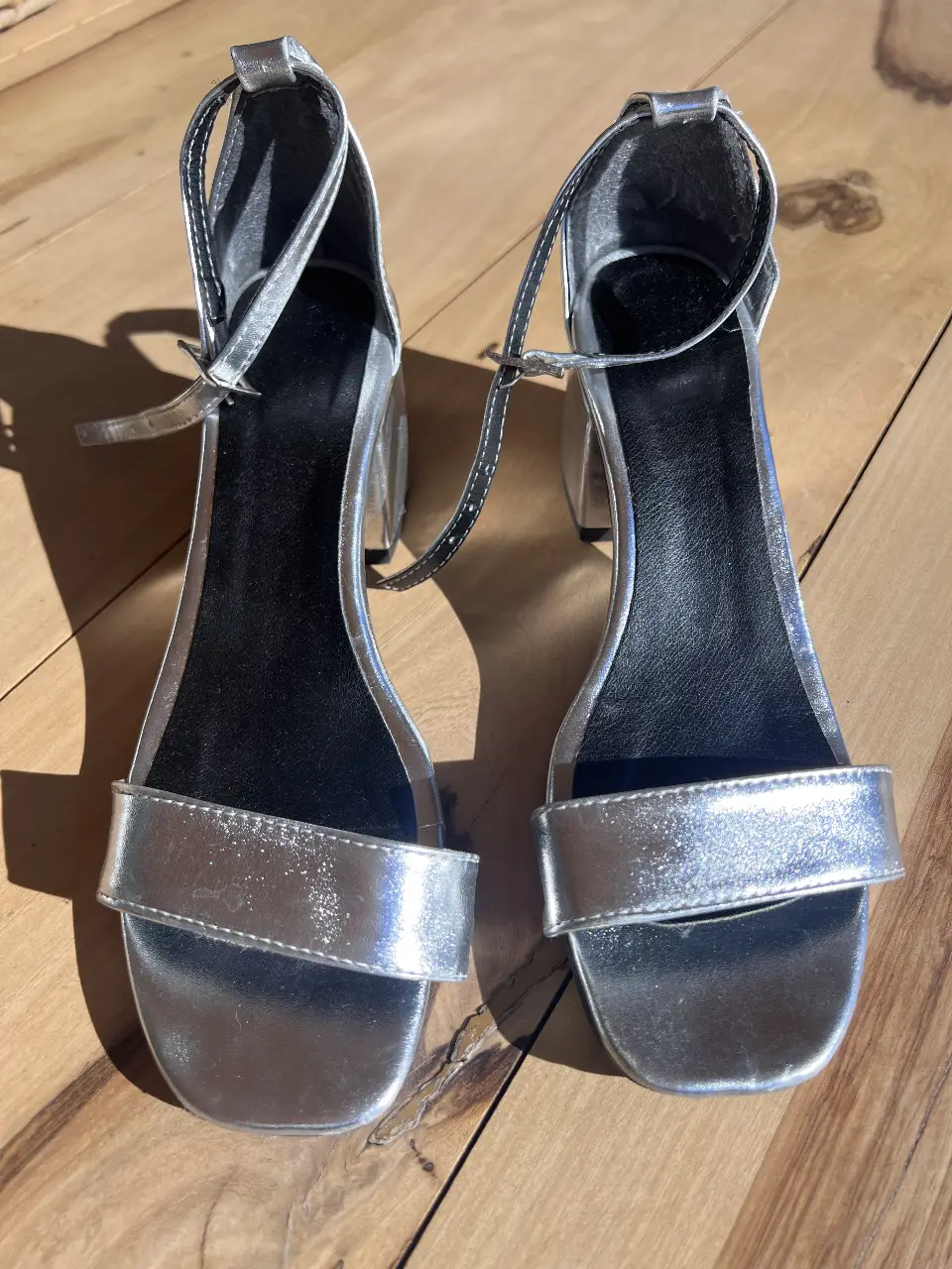 Sandalias plateadas con taco cuadrado y tira en el tobillo. Ideales para fiestas y eventos especiales.