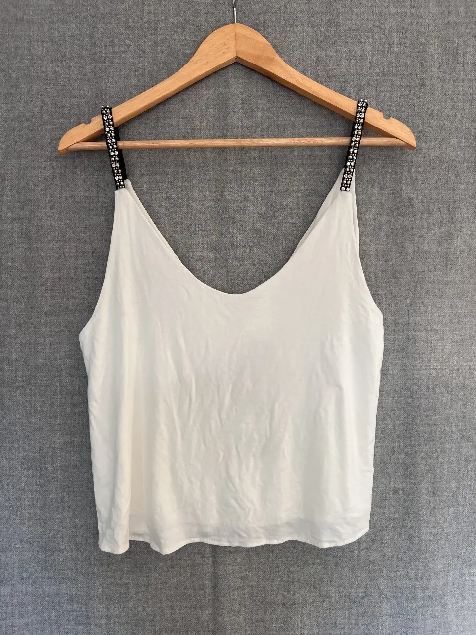 Top blanco con tiras de canutillos bordados. Ideal para un look fresco y elegante.