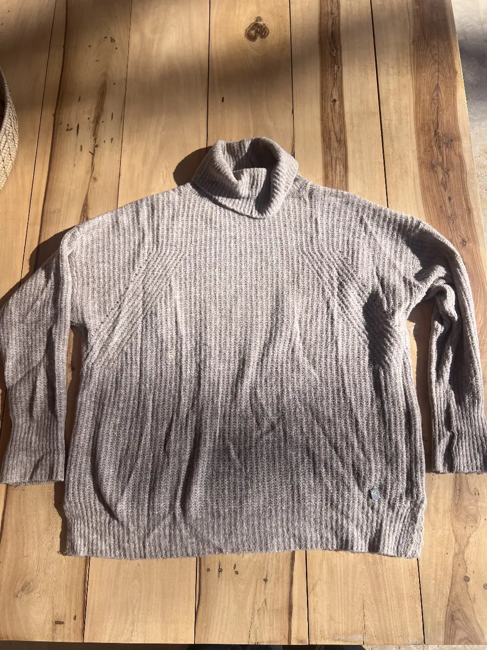 Sweater de cuello alto de tejido grueso, ideal para el invierno. Confeccionado en un tono gris neutro, este sweater ofrece calidez y estilo. Perfecto para un look casual y cómodo.