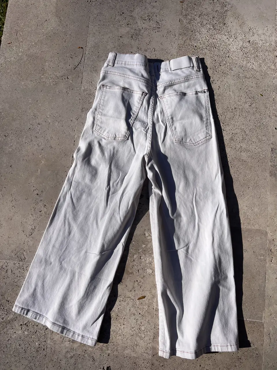 Jeans Cher blancos de corte recto,al tobillo,  con detalles de costuras en color marrón. Talle 26, ideal para un look casual y moderno.