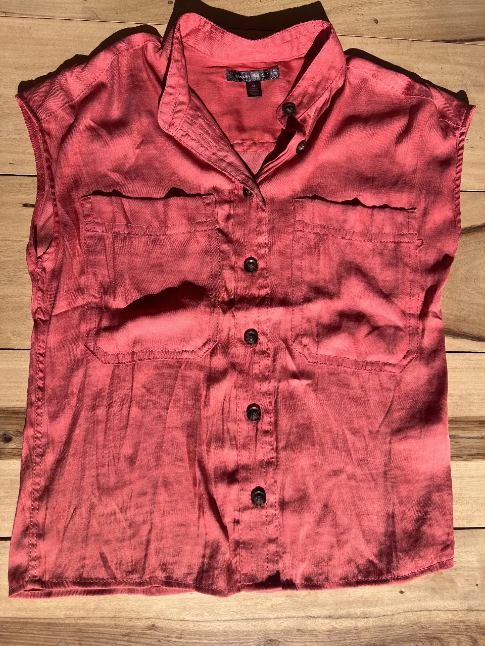 Blusa sin mangas de color coral, con dos bolsillos delanteros y botones. Ideal para un look casual y fresco.