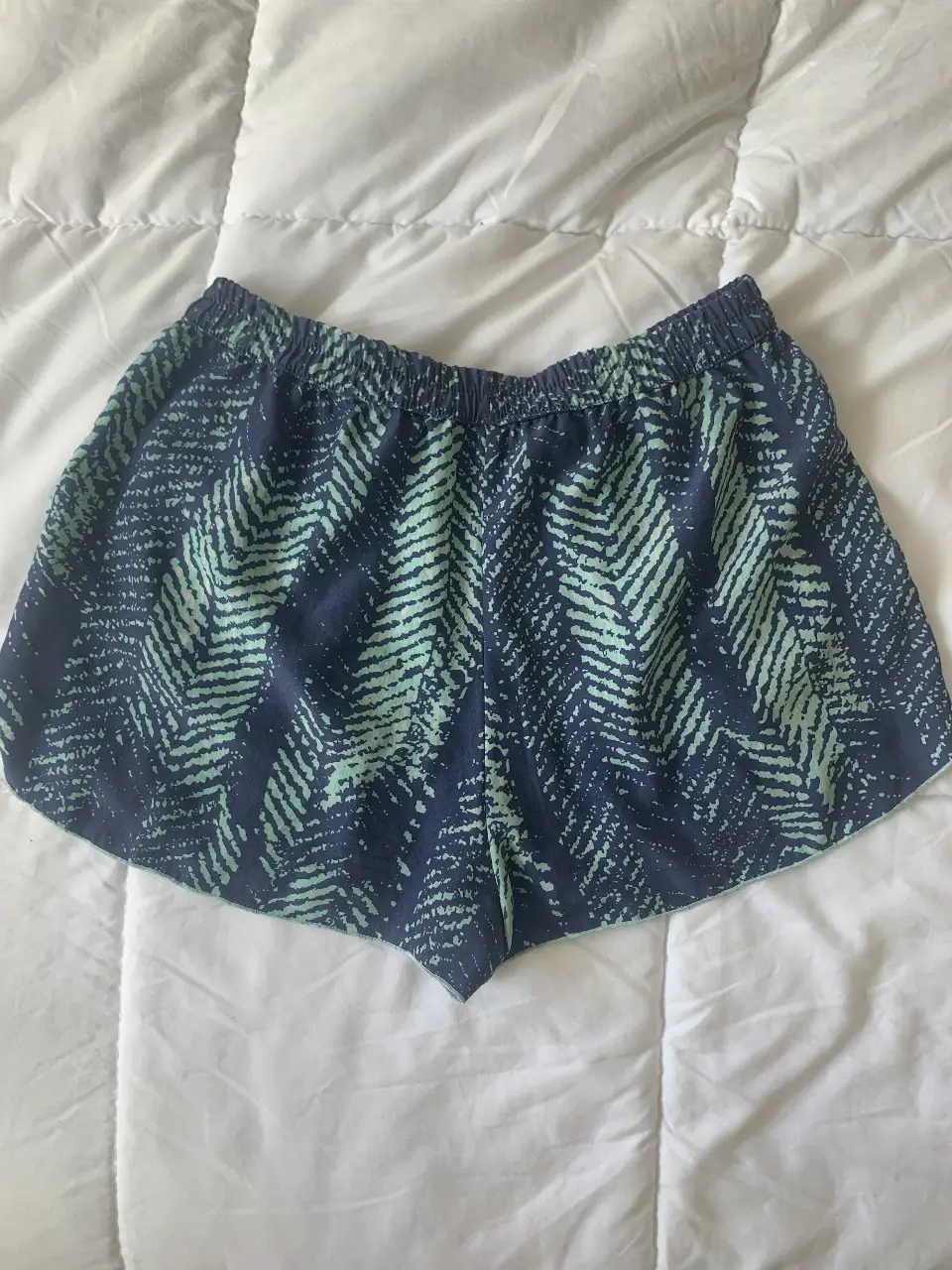 Short deportivo de mujer con estampado de hojas en tonos azul y verde. Ideal para actividades físicas y uso casual.