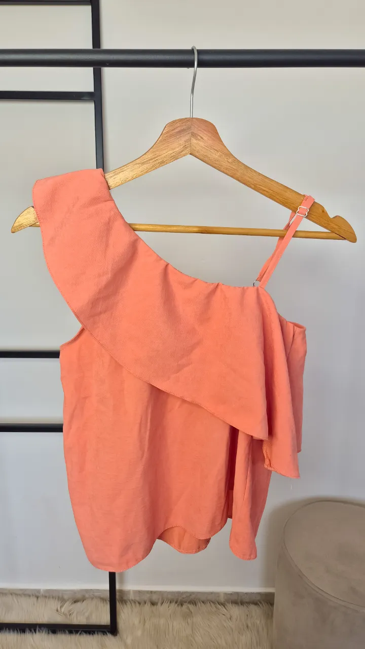 Top de bretel asimétrico con volado en el escote. Bretel regulable.