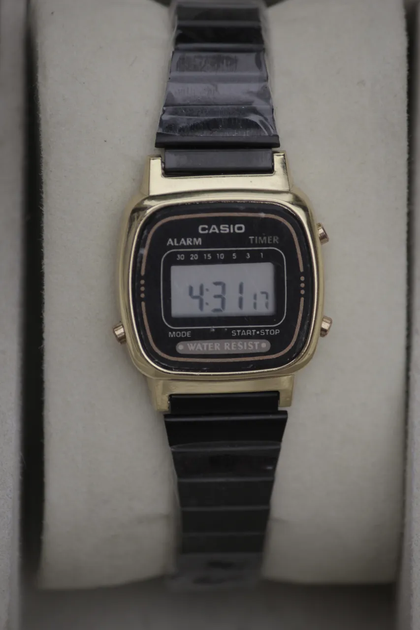 Reloj Casio digital con malla de metal negra y caja dorada. Posee pantalla digital con hora, alarma y timer. Resistente al agua.