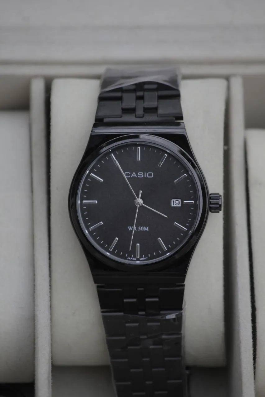 Reloj Casio con malla y caja de acero inoxidable en color negro. Esfera negra con índices y agujas plateadas. Posee fechador.