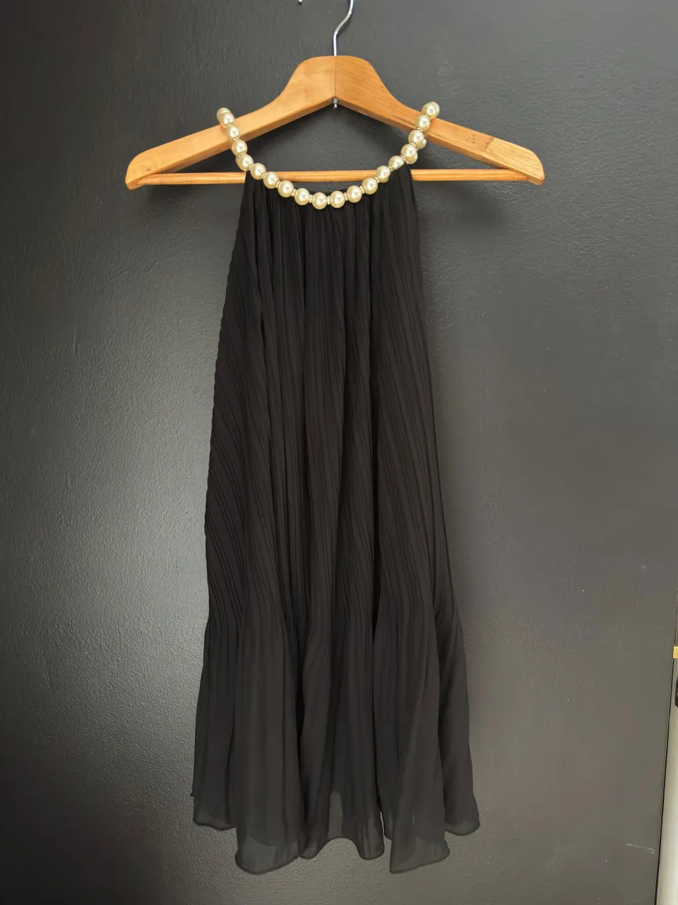 Vestido negro con cuello adornado con perlas. talle equivale a un m aprox (ver medidas). medidas: axila a axila 48cm. sisa 25cm. cadera 56cm.
largo 85cm.Posee un diseño plisado en toda la prenda y un escote halter.