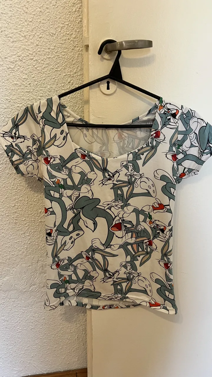 Remera súper canchera con estampa de Bugs Bunny. Ideal para un look divertido y relajado. Manga corta y escote cuadrado.