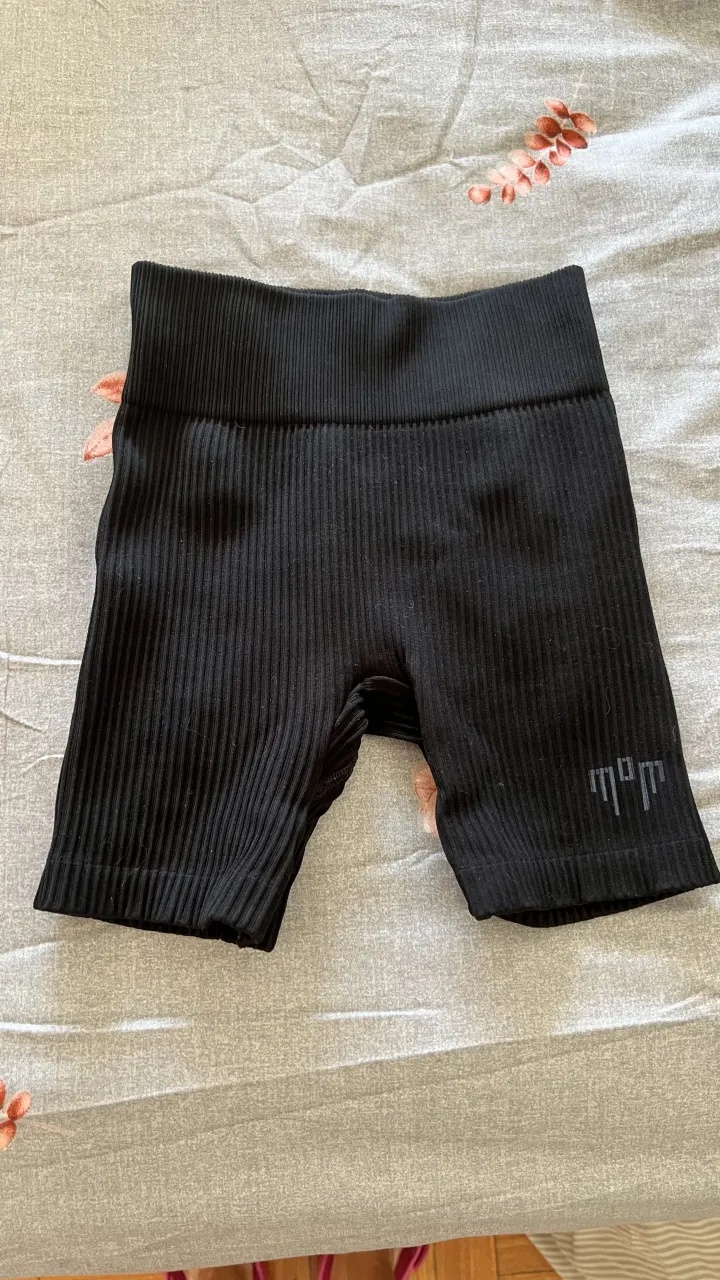 Shorts de ciclista negros, de tejido acanalado y tiro alto. Perfectos para entrenar o para un look deportivo y cómodo.