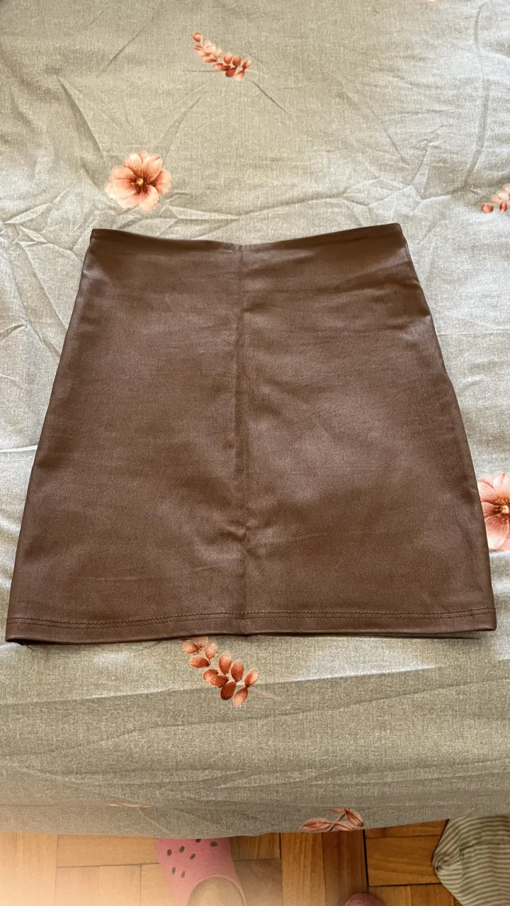 Pollera marrón de cuero sintético, tiro alto, corte recto y mini. Ideal para un look canchero y moderno.