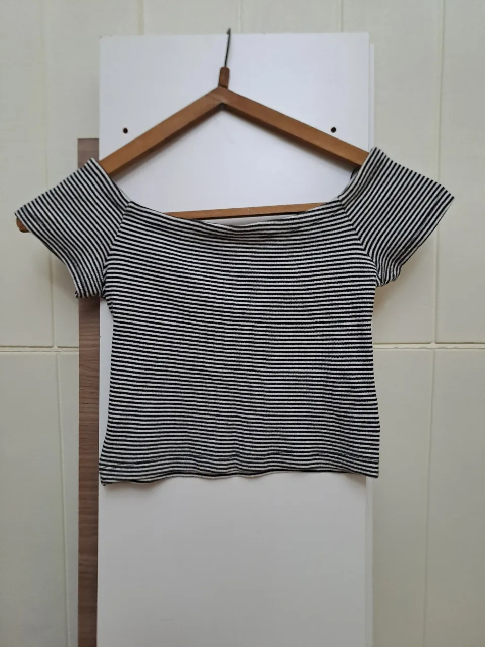 Remera a rayas blancas y negras, con escote Bardot y mangas cortas.