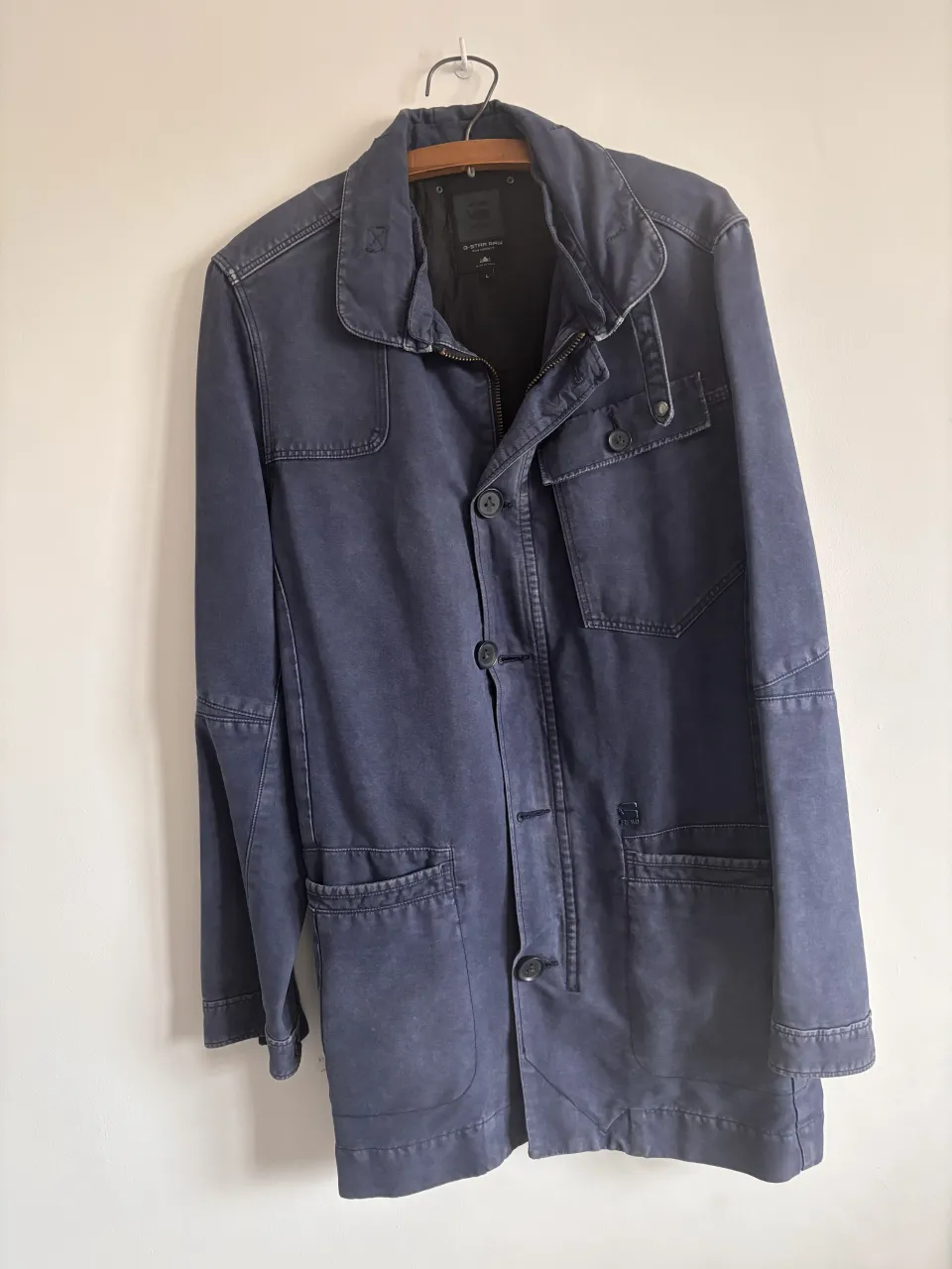 Campera de gabardina azul marino, ideal para entretiempo. Posee bolsillos amplios y un diseño clásico con botones.