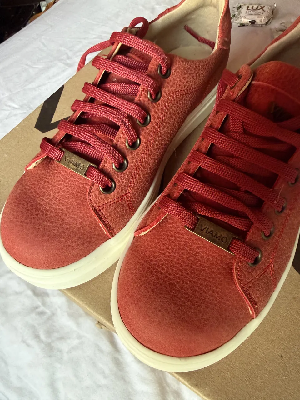 Zapatillas de cuero color rojo con cordones. Detalle de marca en la lengüeta y en la suela.