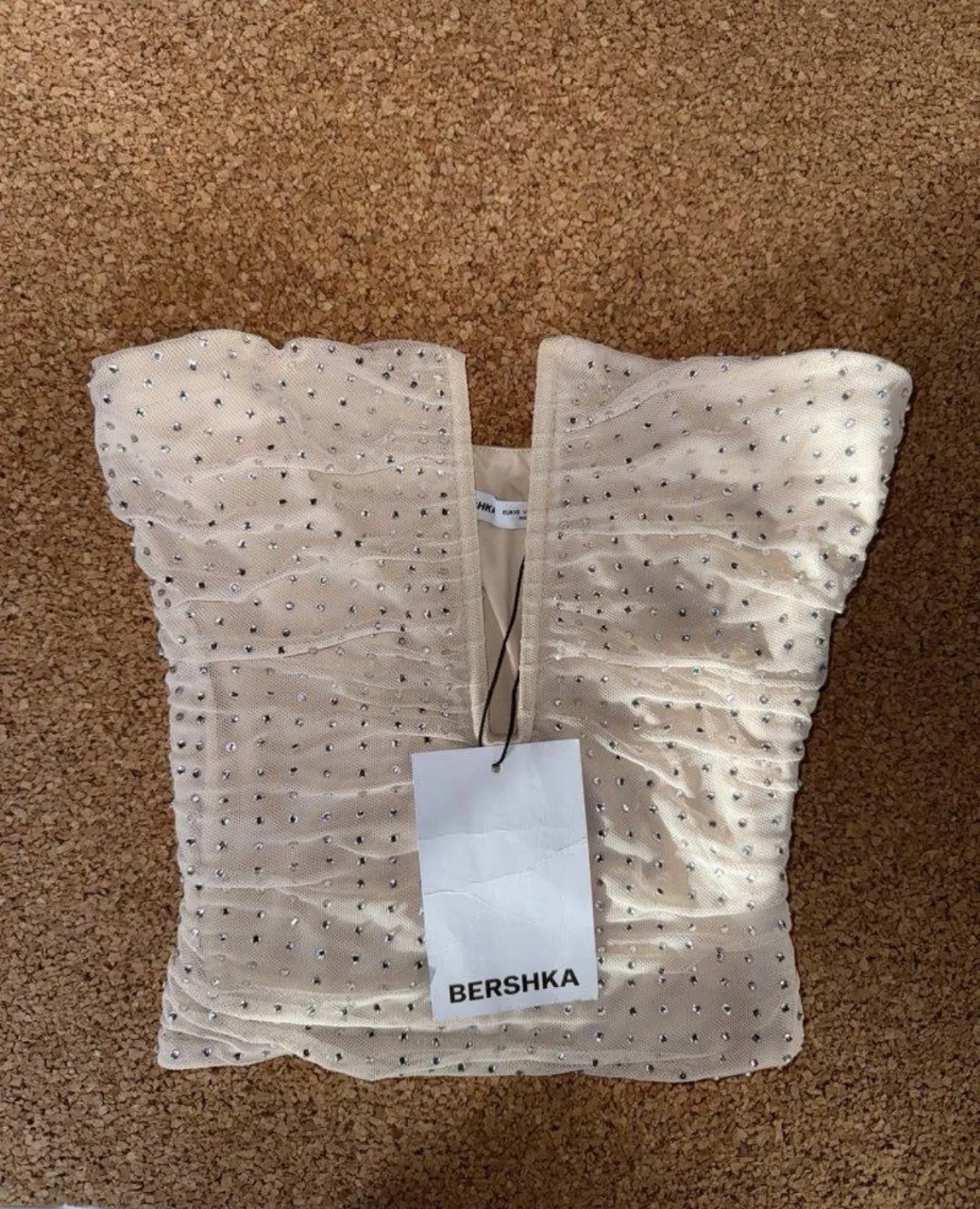 Top de tul con brillos y fruncido. Escote en V.