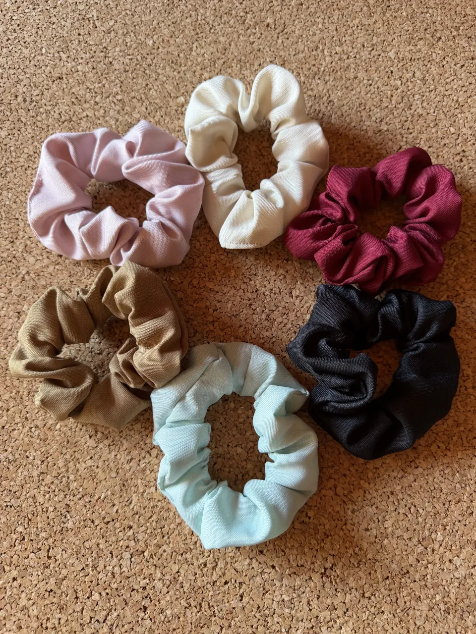 Set de 6 scrunchies de tela en colores rosa pálido, blanco, bordo, marrón, celeste y negro.
