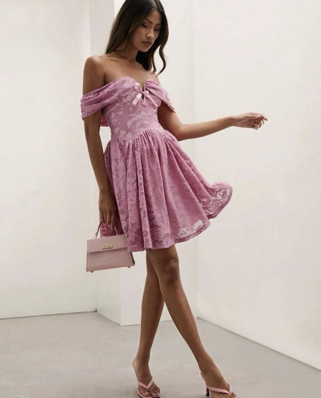 Vestido rosa de encaje con escote Bardot y lazo en el busto. Posee mangas cortas abullonadas y falda con vuelo.
solo 1 uso 