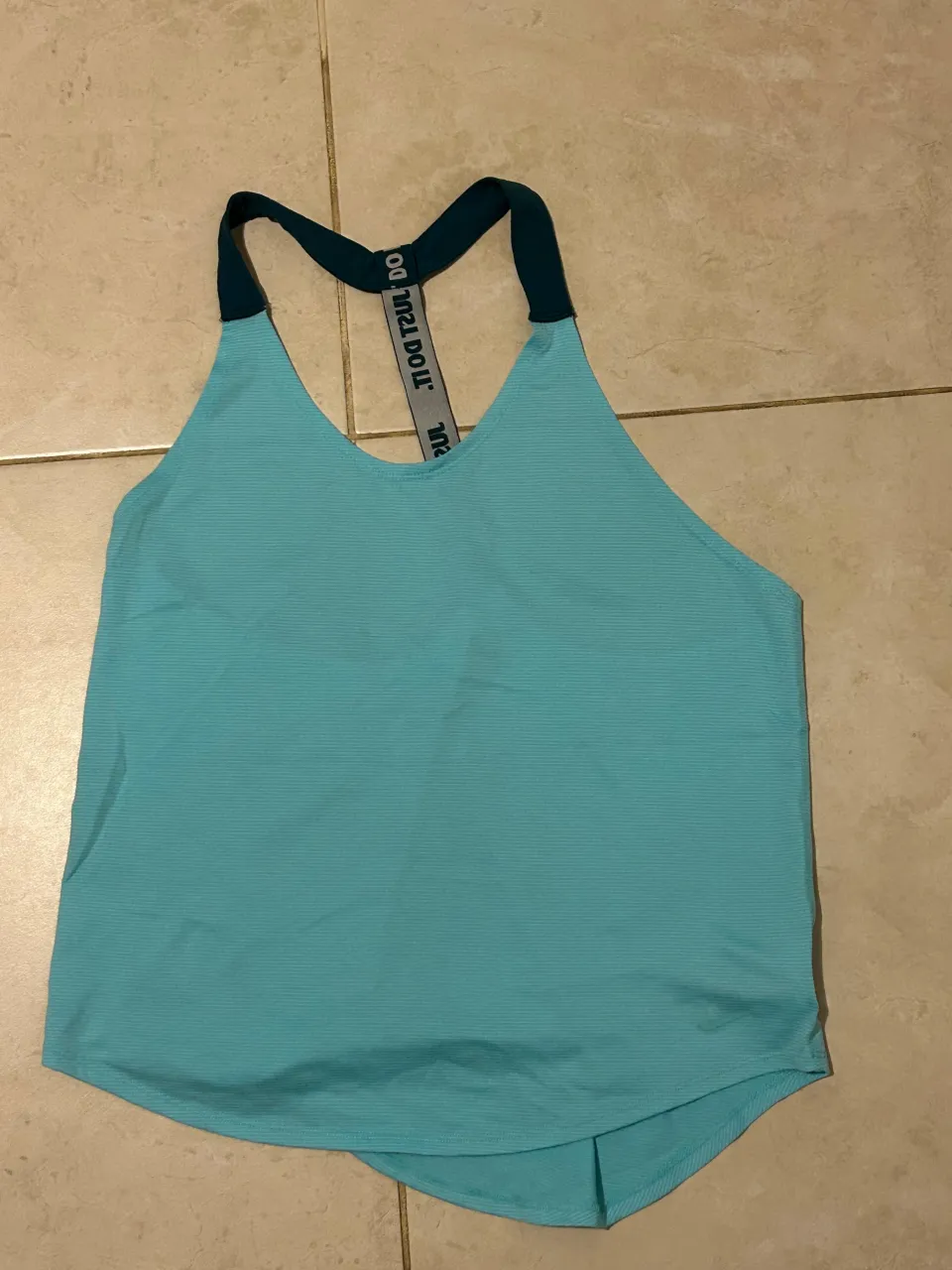 Musculosa deportiva Nike, ideal para entrenar o para un look casual. Su diseño moderno y cómodo te permite moverte con total libertad. Perfecta para combinar con calzas o shorts.